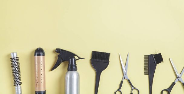  Scissors, comb and other hair styling tools on yellow background. - Foto, imagen