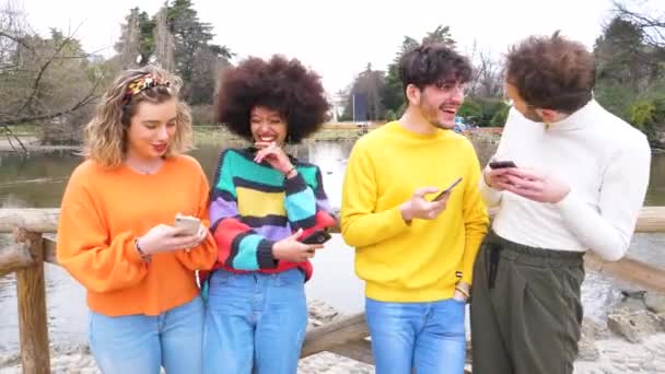 Groep multi-etnische jonge vrienden millennials met behulp van mobiele telefoons verslaafd aan technologische trends volgen en chatten op sociale media - Video