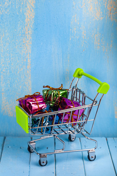 Shopping cart with colorful gifts. Buying gifts for the holiday. - Foto, Bild