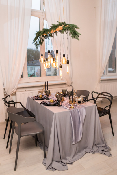 Widok z boku świąteczny stół z pustymi kieliszkami do wina i czarny talerz. Koncepcja Bożego Narodzenia i Nowego Roku - Zdjęcie, obraz