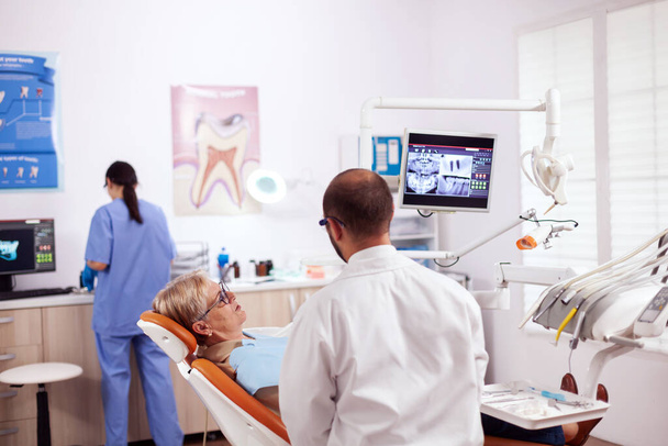 Senior woman discussing with dentist - Photo, Image