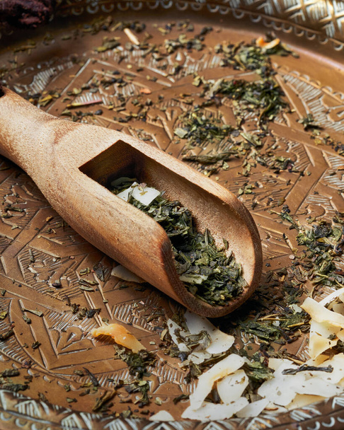 Sencha πράσινο τσάι αρωματισμένο με ροκανίδια καρύδας, ανανά και ξύσμα εσπεριδοειδών σε υφή banner φόντο. Τσάι Πίνα Κολάντα. Επιλεκτική εστίαση. Αντιγραφή χώρου. Τσάι Pina Colada. - Φωτογραφία, εικόνα