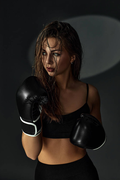 sporty woman with black boxing gloves - Fotó, kép