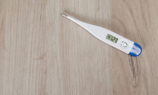 Medizinisches Thermometer isoliert auf Holzgrund. - Foto, Bild