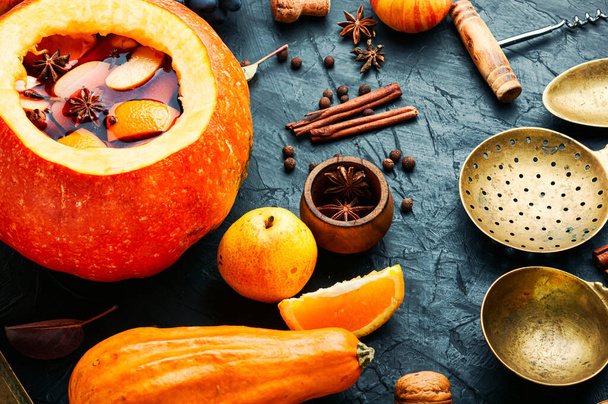 Autumn alcoholic drink mulled wine in pumpkin. - Фото, изображение