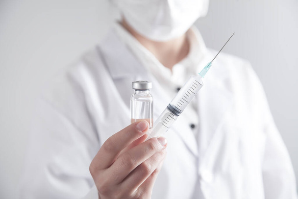 Médico segurando seringa e vacina.  - Foto, Imagem
