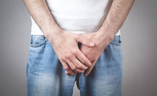 Caucasian man with hands holding his crotch. Inflammation of the prostate, erection problems - Фото, изображение