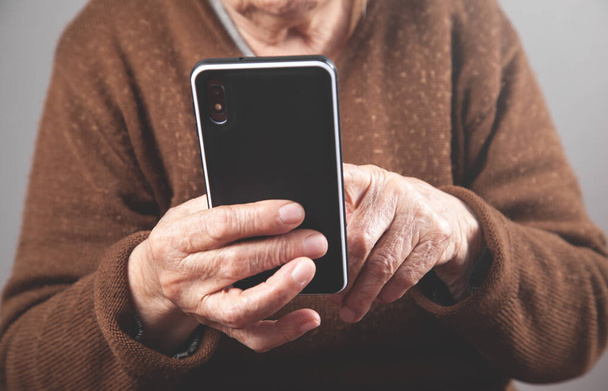 Donna anziana caucasica utilizzando smartphone. - Foto, immagini