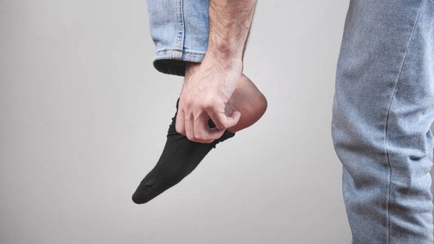 Man is wearing socks into his feet. - Foto, Bild