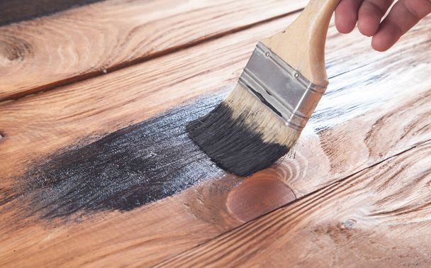 Man painting wood with a brush. - Foto, Imagen