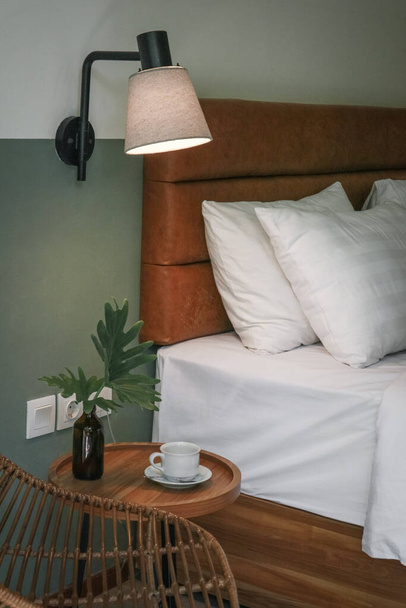Белые подушки, одеяло и пододеяльник на кровати и тумбочке - Фото, изображение