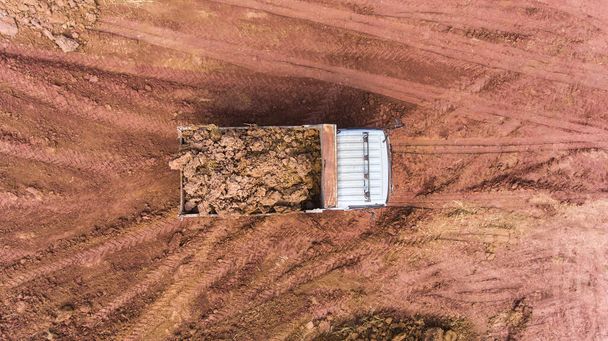 Ανατρεπόμενο φορτηγό εκφορτώνει χώμα στο εργοτάξιο. - Φωτογραφία, εικόνα