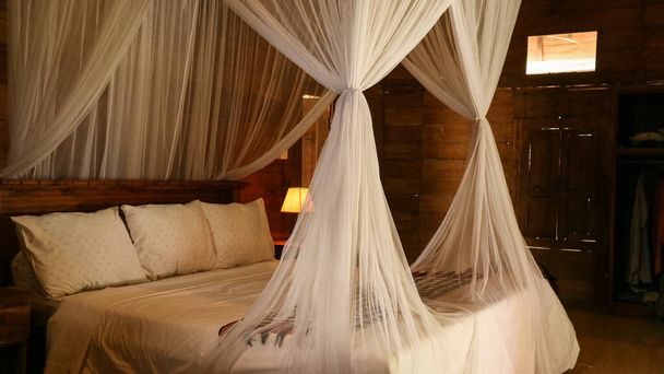 Traditional balinese cozy canopy bed in bedroom  - Fotografie, Obrázek