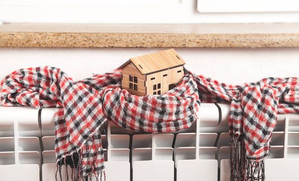 House model and scarf on radiator. Home. Winter. Energy. Efficiency. Heating - Foto, afbeelding