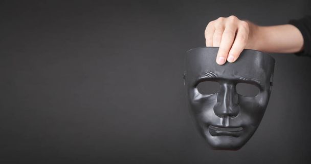 Man holding black mask. Fake, anonymous - Foto, afbeelding
