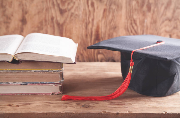 Gorra de graduación con libros en el escritorio de madera. Educación - Foto, imagen
