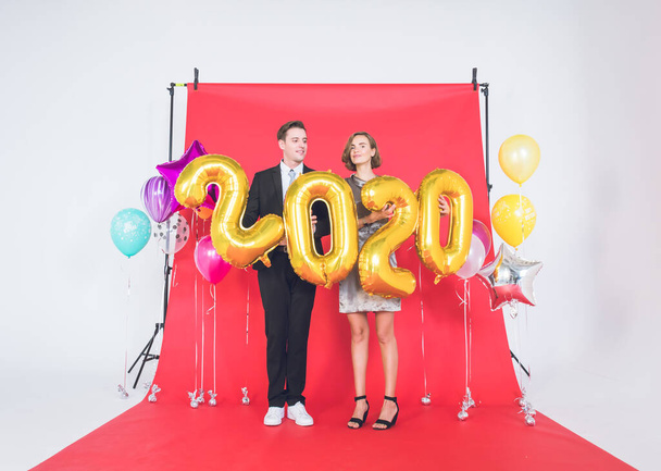 Ευτυχισμένα ζευγάρια στο στούντιο με την έννοια του Happy New Year 2020. - Φωτογραφία, εικόνα