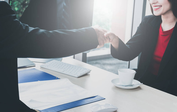 Shaking hands of business people between man with woman in the office for collaborative teamwork. Boss shake hands with job applicants to welcome. Shake hands for partnership approval. - Photo, Image