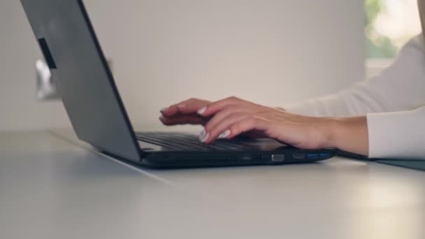 Female hands of business woman using typing on laptop notebook keyboard sit at home office desk working online with pc software apps technology concept, close up side view - Materiał filmowy, wideo
