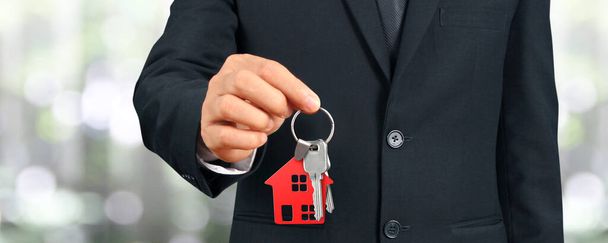 Immobilienmakler übergibt Hausschlüssel in der Hand - Foto, Bild