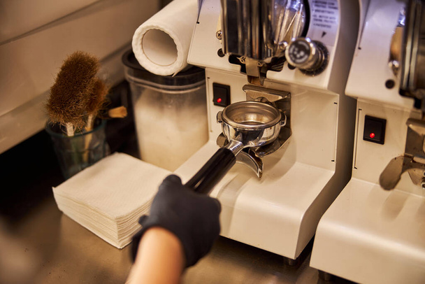 Barista getting fresh-ground coffee in modern cafe - Photo, Image
