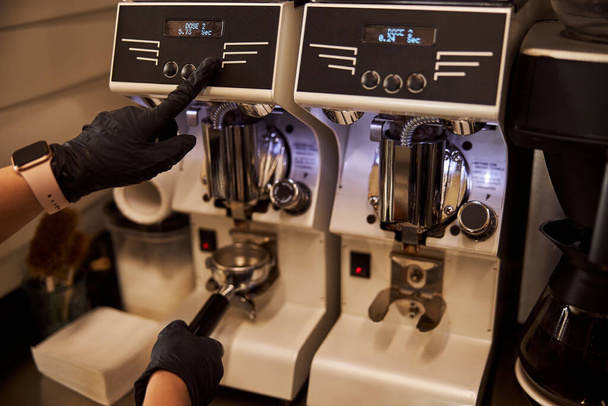 Barista experimentado usando molinillo de café moderno en el trabajo - Foto, imagen