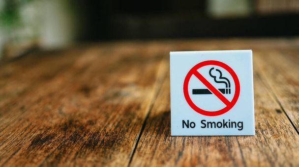 Не кури табличку. Не курить этикетку в общественных местах. Запрет на курение на деревянном столе в отеле - Фото, изображение