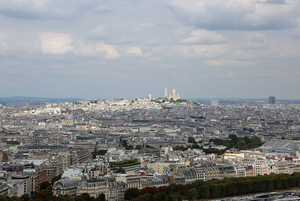 Paris manzarası ve MontMartre Kilisesi tepede ve Eyfel Kulesi 'nden birçok bulut. - Fotoğraf, Görsel