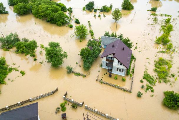 Vista aérea de la casa inundada con agua sucia a su alrededor. - Foto, Imagen