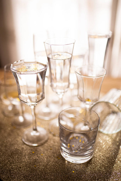 Several champagne glasses over gold christmas background. Celebrating new year concept. - 写真・画像