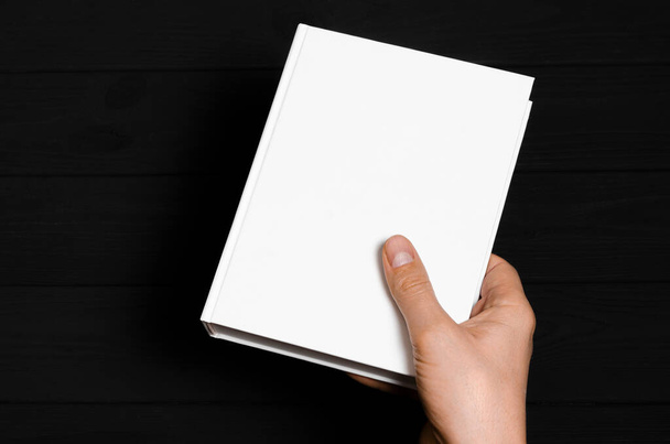 Mockup. Men's hands holding closed book with blank cover on light background - Photo, Image