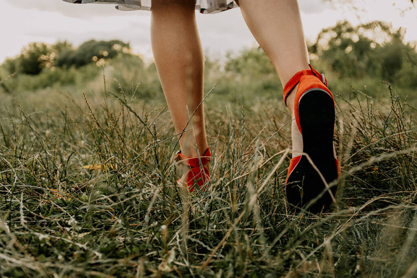 Жінка в одязі гуляє на газоні, танцює і розважається на траві
 - Фото, зображення