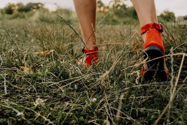 Mujer en vestido camina por el césped, bailando y divirtiéndose en la hierba - Foto, imagen
