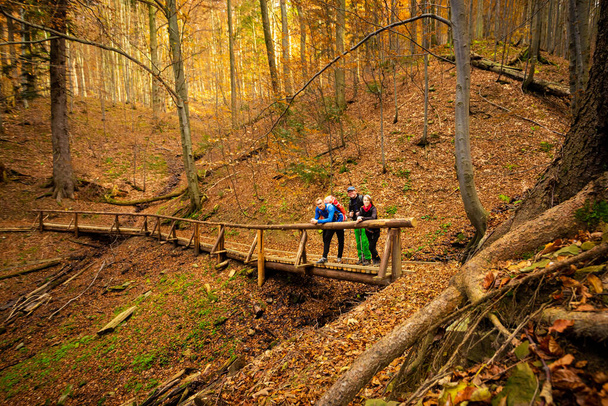 Rodzinny trekking dorosłych turystów w jesiennych lasach, zdjęcie zrobione w polskich Beskidach, Rezerwat Srubita, Wielka Racza - Zdjęcie, obraz