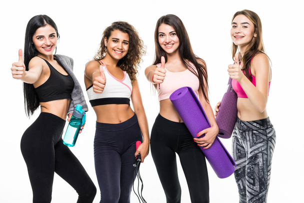 Quatre filles de fitness avec les pouces vers le haut sur fond blanc - Photo, image