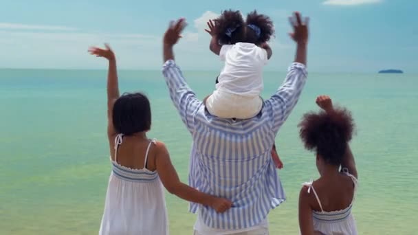 Αφροαμερικανικές οικογένειες κουνάνε τα χέρια τους στην παραλία. - Πλάνα, βίντεο