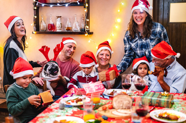 Famille multi-génération s'amuser à la fête de Noël dîner - Vacances d'hiver x Noël concept avec les parents et les enfants de manger ensemble ouvrir des cadeaux à la maison - Focus sur le cadre moyen - Filtre chaud - Photo, image