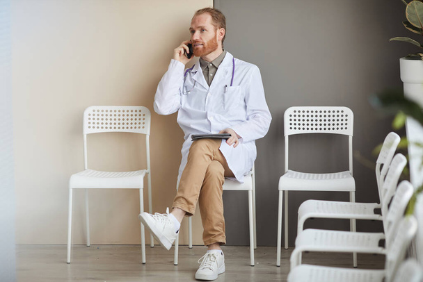 Γιατρός μιλάει στο τηλέφωνο κατά τη διάρκεια του διαλείμματος - Φωτογραφία, εικόνα