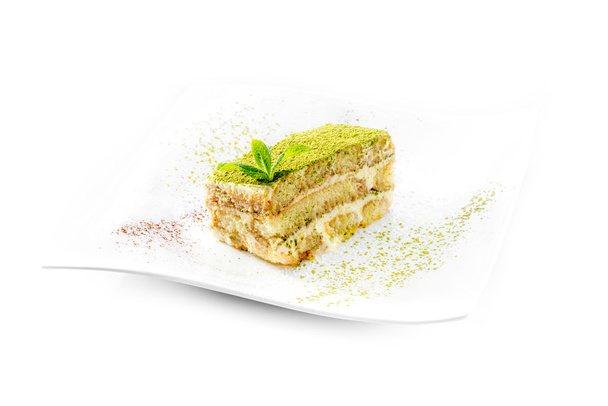 Tiramisú con polvo de té verde aislado sobre fondo blanco
 - Foto, Imagen