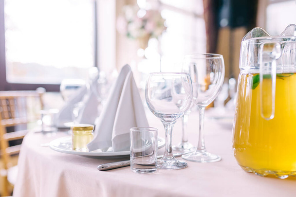 Verres et assiettes sur la table au restaurant. Table à manger romantique de luxe avec ustensiles vides - Photo, image