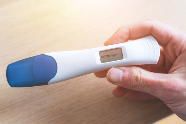 Woman hand holding pregnancy test, result is pregnant,Schwanger - Foto, Imagen