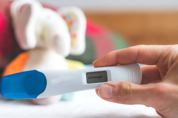 Woman hand holding pregnancy test, result is pregnant,Schwanger - Foto, Bild