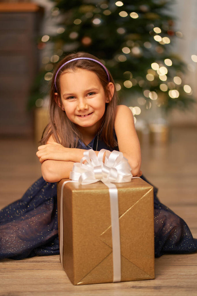 Happy childhood, Christmas magic fairy tale. Little girl dreams before opening Santa's present for Christmas. - Valokuva, kuva