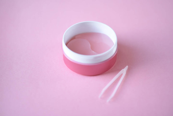 Pink hydrogel eye patches n a pink background. Bathroom treatments. Homemade face care. - Foto, imagen