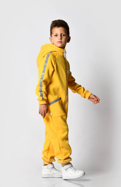 Stylish kid schoolboy in a warm autumn suit, yellow overalls with a zipper - Zdjęcie, obraz
