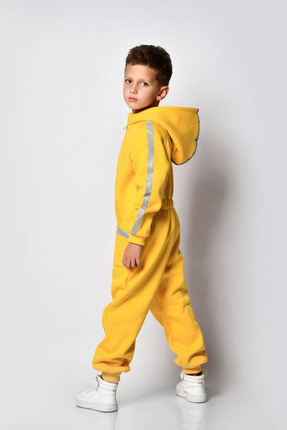 Boy posing for camera in yellow warm jumpsuit - 写真・画像