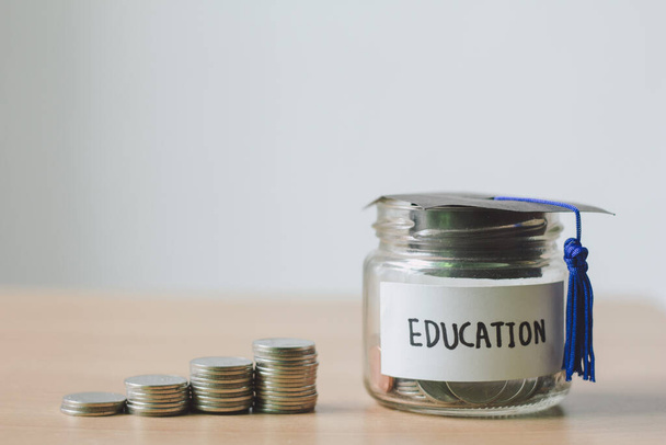 Glazen pot bespaar geld budget voor onderwijs in de toekomst op houten tafel. - Foto, afbeelding