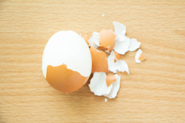 Ahşap masa arkasında soyulmuş yumurta.. - Fotoğraf, Görsel