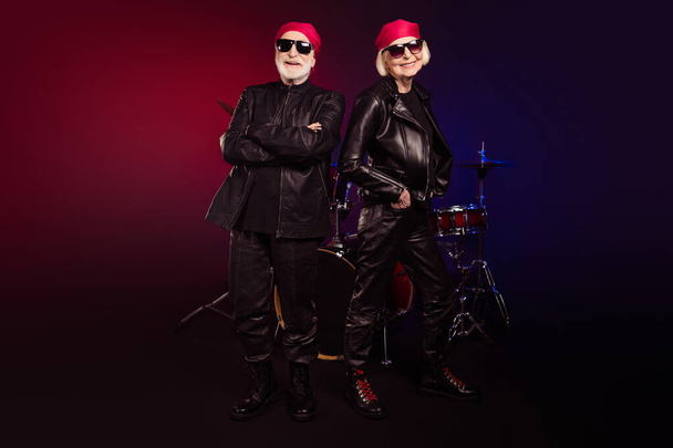 Photo of two retired cool aged lady man rock legend group all life on stage concert photographing drum instruments behind wear trendy rocker leather outfit isolated black color background - Fotó, kép