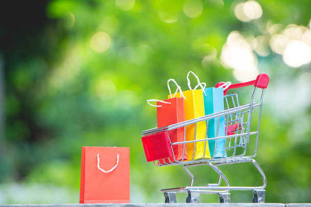 Paper bags on miniature shopping cart,shop online,e-commerce. - Foto, imagen